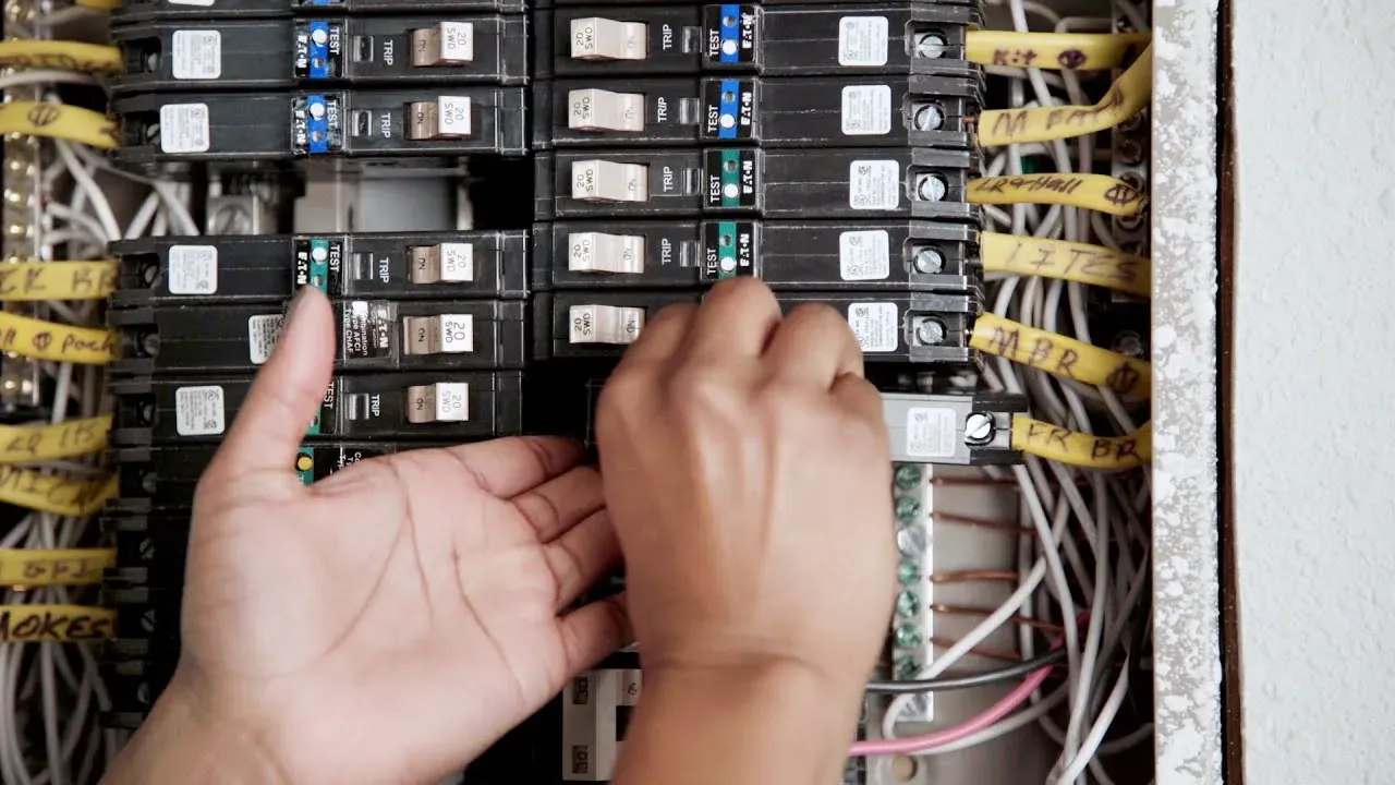 Electrician replacing a breaker in a labeled home panel full of AFCI breakers
