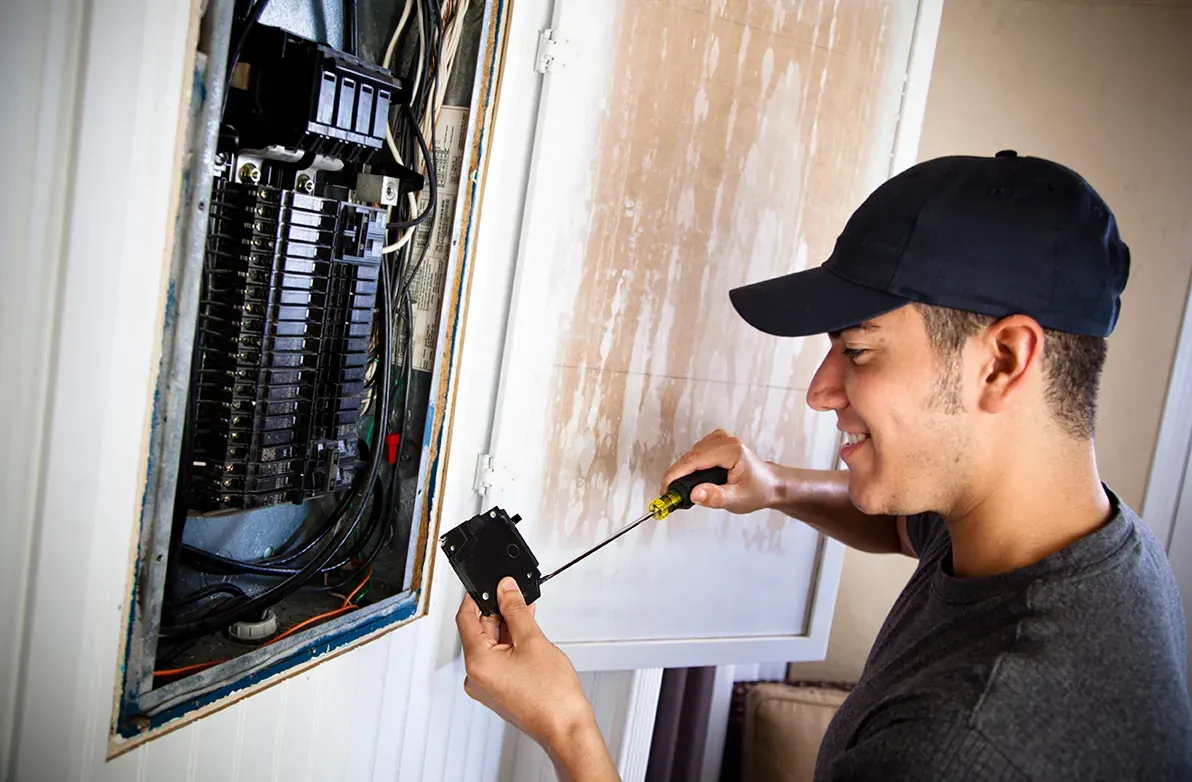 Electrician replacing a breaker in the electrical panel of an older home