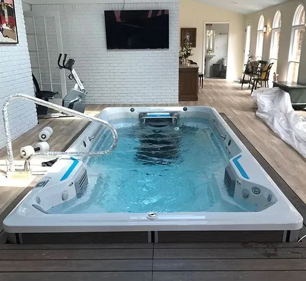 New indoor swim spa set into a deck in a sunroom, wired and filled