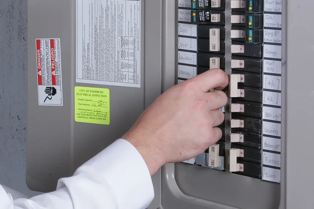 Hand resetting a breaker in a labeled home electrical panel